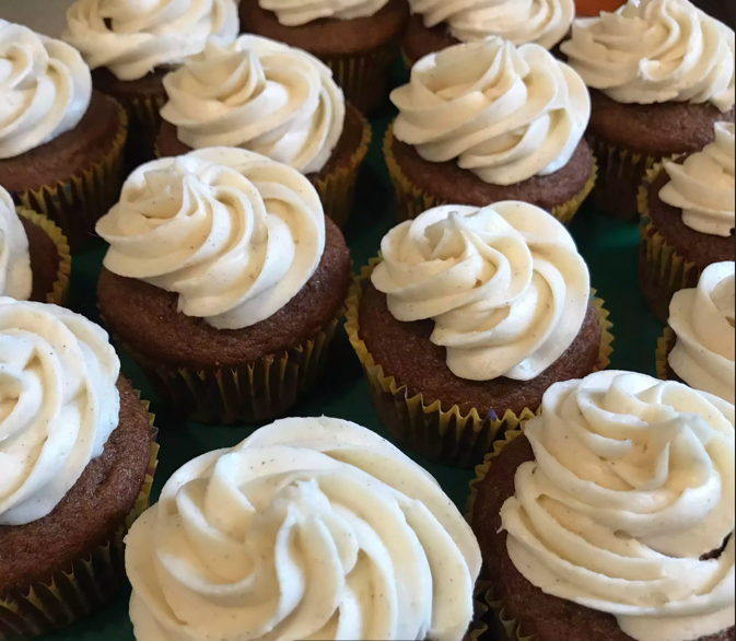 Freshly baked pumpkin cupcakes topped with creamy frosting and a sprinkle of cinnamon.
