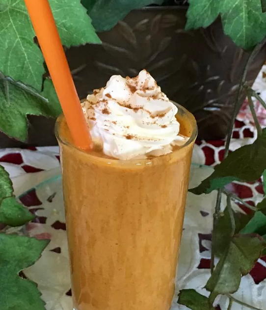 Chilled Pumpkin Spice Smoothie garnished with whipped cream and a sprinkle of cinnamon.