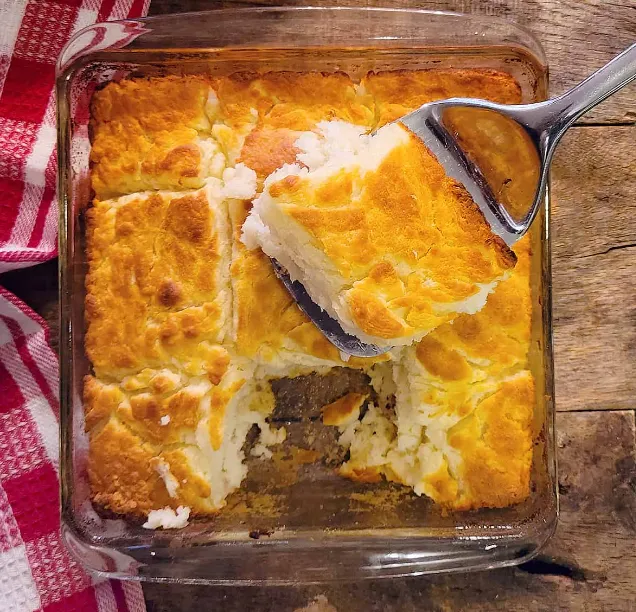 Freshly baked butter swim biscuits on a rustic wooden table.