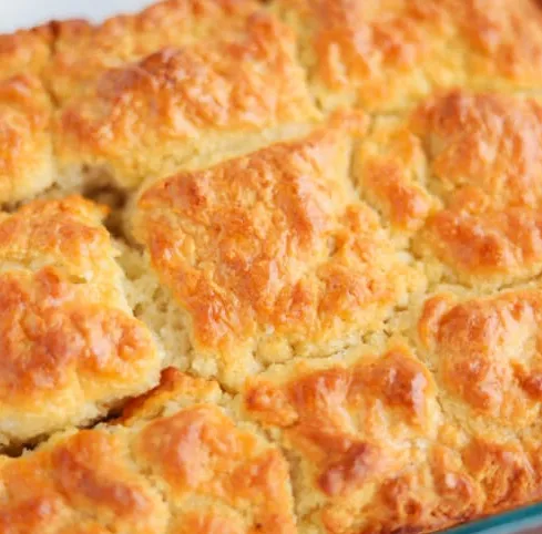 Freshly baked butter swim biscuits on a rustic wooden table.