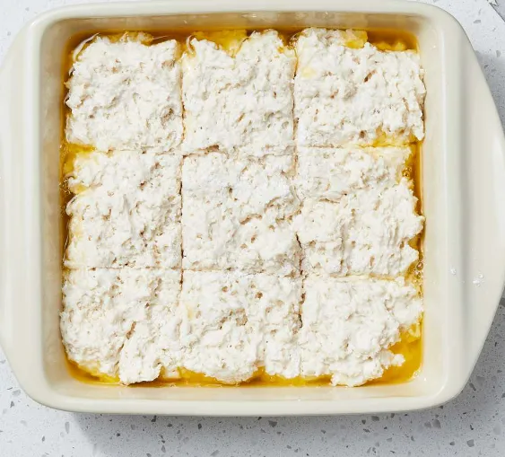 Freshly baked butter swim biscuits on a rustic wooden table.
