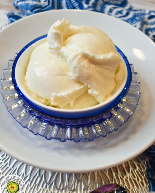 Creamy vanilla ice cream scoop with a Ninja Creami machine in the background.