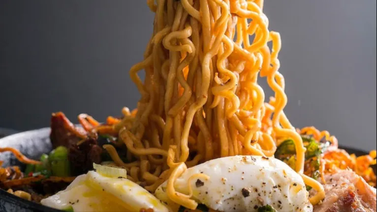 A bowl of delicious Ngo Ngae noodles garnished with spring onions, capturing the essence of Thai cuisine